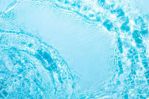 Gentle ripples create patterns on a bright blue water surface, sparkling unde Foto stock