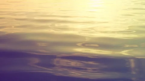 Gentle ripples create a soothing pattern on the water as the sun sets, casting Stock Footage 316540105