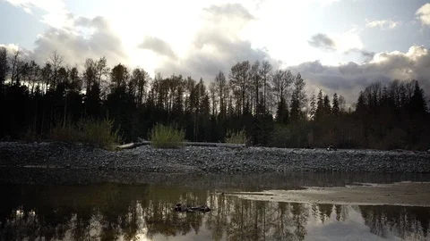Gentle ripples disturb the reflection in a slow moving creek Stock Footage 123299873