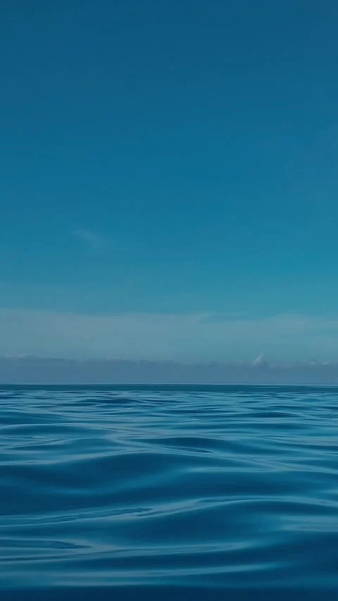 Gentle ripples on glassy surface beneath soft sunrise gradient Video stock 335849019