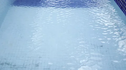 Gentle Ripples Over Blue Pool Tiles with Visible Dirt Stock Footage 314742596