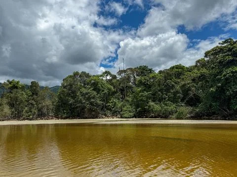 Gentle river reflecting gray cloud. Stock Photos