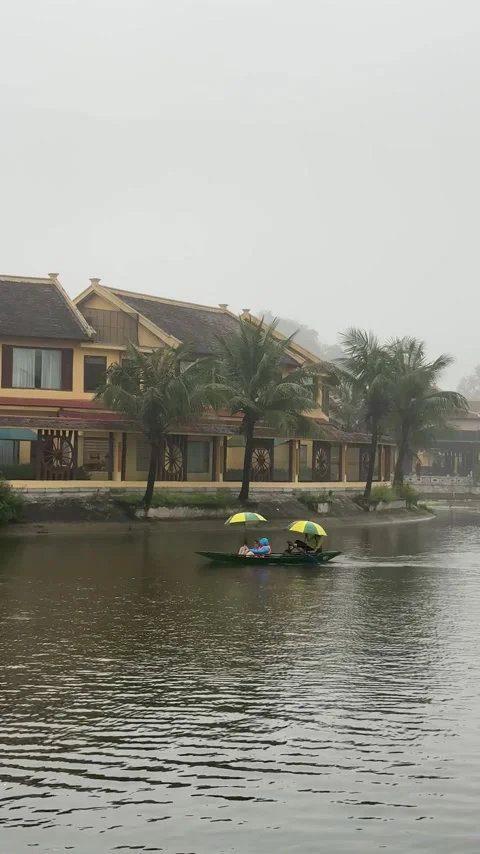 Gentle rowing through the misty waters of Ninh Binh's serene landscape with Stock-Footage 302264386