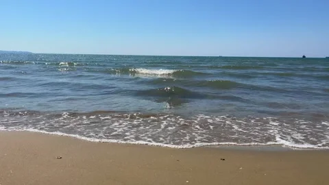 Gentle Sea Waves Hitting Sandy Shore Under Clear Blue Sky Stock Footage 310232823