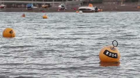 Gentle Sea Waves Lap 2 yellow Buoys within view of Teignmouth Harbor 動画素材 46364744
