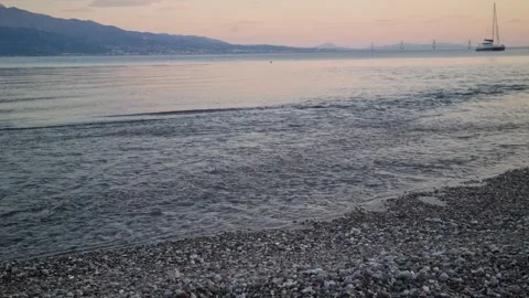 Gentle sea waves on pebble beach at peaceful sunset Stock Footage 335758288