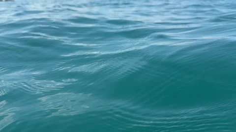 Gentle sea waves roll across the open ocean under a clear sky, creating a calm w Stock Footage 340150277