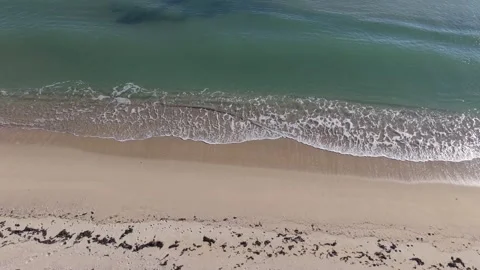 Gentle Sea Waves Rolling onto Sandy Beach | Relaxing Drone View Stock Footage 325720153