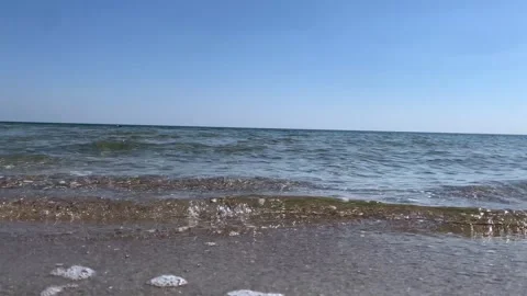 Gentle Sea Waves on Sandy Shore Under Clear Blue Sky Stock Footage 333200262
