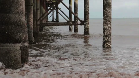 Gentle Sea Waves Wash Base Pillars of Teignmouth Pier on Sand Beach Stock-Footage 46510329