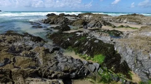 Gentle side-ward pan over rocks and seaweed, with distant headland and horizon. Stock Footage 65397569