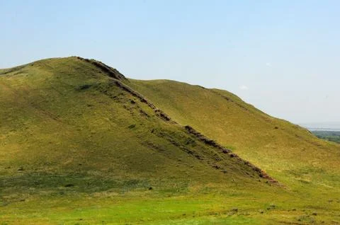 The gentle slope of a high mountain with parallel rows of stony formations .. 库存照片