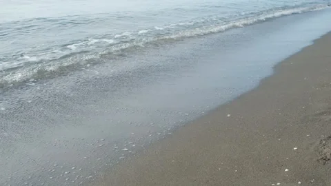Gentle small calm long waves washing sandy beach shore. Video stock 311472189