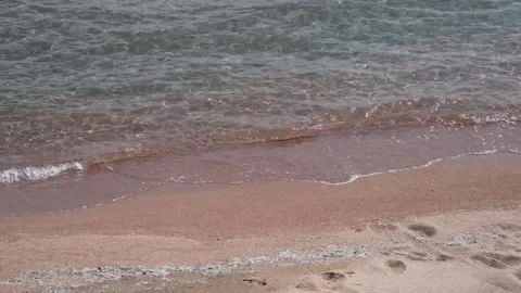 Gentle small waves on a sandy shore Stock Footage 260555894