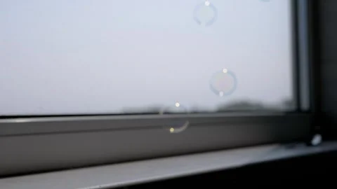 Gentle Soap Bubbles Float and Burst by a Window Stock-Footage 316178559