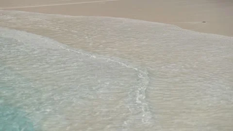 Gentle tide on pale sandy beach Видео 329965829