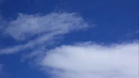 Gentle time lapse of soft white clouds floating through a clear blue sky Stock Footage 322166583