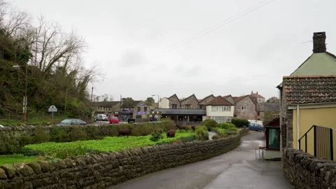 Gentle tracking shot beside the main road in Cheddar, cars reflecting warm Vídeo Stock 331214545