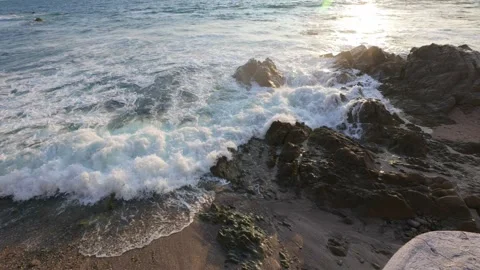 A gentle wave breaking on a rocky beach Stock Footage 345867276