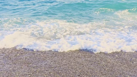 Gentle wave washing over a pebbly Mediterranean beach shore with receding w.. Vídeo Stock 340241561