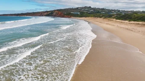 Gentle waves along a deserted sandy beach Stock Footage 325276554