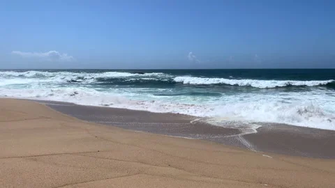 Gentle waves breaking on sandy beach in Portugal in Spring. Slow motion. Stock Footage 239201301
