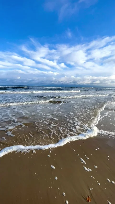Gentle waves breaking on a sandy beach under a beautiful sky Stock Footage 297613017