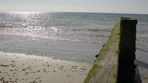 Gentle waves from a calm sea breaking on a sandy beach at Littlehampton in We Video stock 219882995