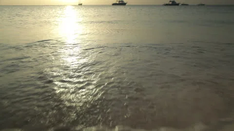 Gentle waves crash on the beach at sunset Video stock 22637316