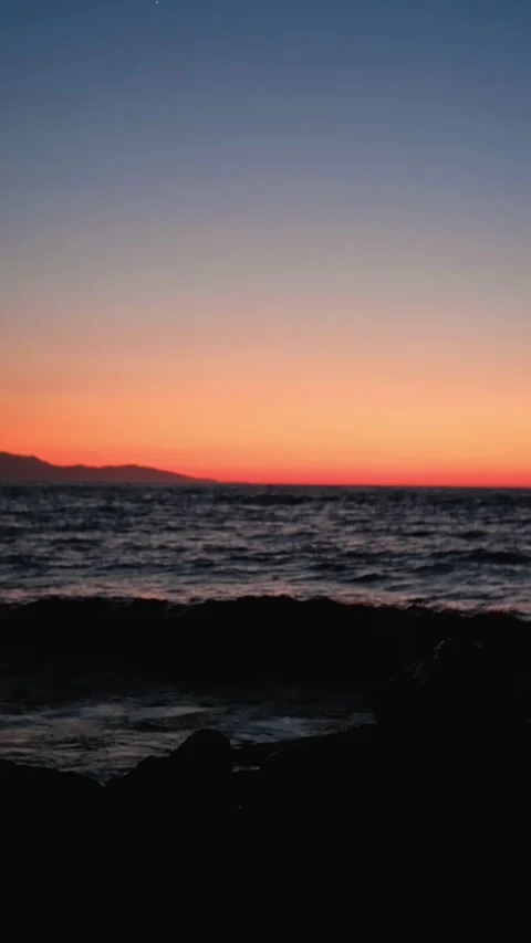 Gentle waves crashing on rocks during beautiful sunset Stock-Footage 310539600