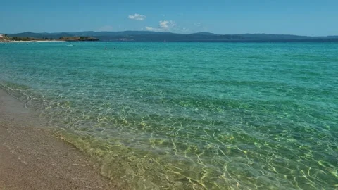 Gentle waves lap at golden sand. Trani Ammouda, Greece Stock Footage 339612562