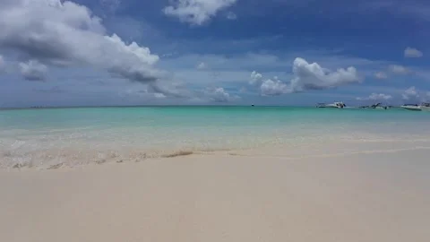 Gentle waves lapping against the white sand shore of a pristine Caribbean Vídeos de archivo 336814310