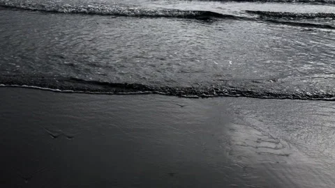 Gentle waves lapping black sand beach Stock Footage 231500036