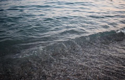Gentle Waves Lapping on Pebble Beach at Twiligh Stock Photos