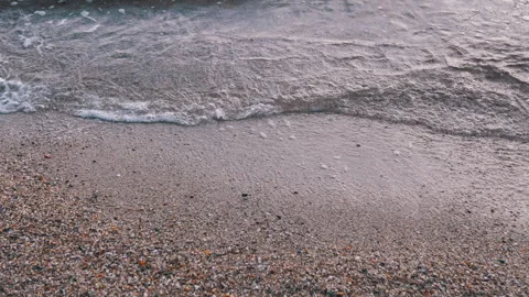 Gentle Waves Lapping a Pebbled Shore, Showcasing Natures Beauty and Evoking Calm Stock Footage 312015674