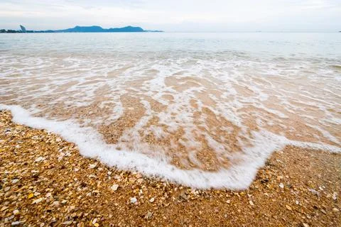 Gentle waves lapping sandy shore coastal beach nature scene serene environm.. 写真素材