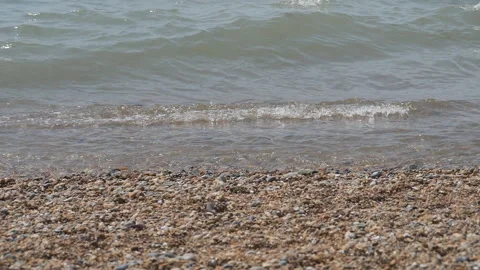 Gentle waves lapping onto a shingle and pebble beach. Stock Footage 337663753