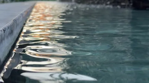 Gentle waves move across a calm water surface reflecting bright sunlight and 库存影片 334116281