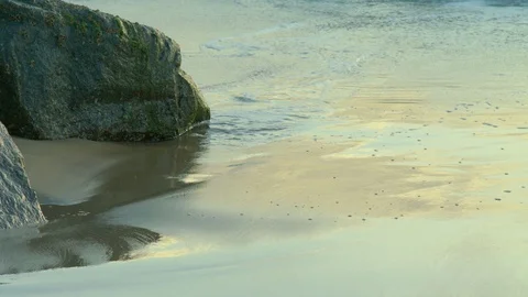 Gentle waves over beach and rocks Stock Footage 92344551