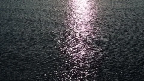 Gentle waves rippling on the calm sea surface reflecting the sunlight in slow Stock Footage 345758149