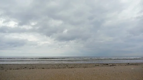 Gentle Waves Roll Onto A Beach Beneath and Overcast Sky Stock Footage 91865276