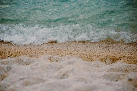 Gentle waves roll onto a beach of small pebbles. Surf on the beach. Backgroun Foto stock