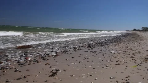 Gentle waves rolling on a pebble and sand beach Stock Footage 297515197