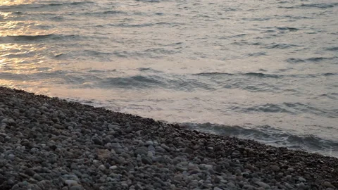 Gentle waves rolling on pebble beach at sunset. Stock Footage 311456814