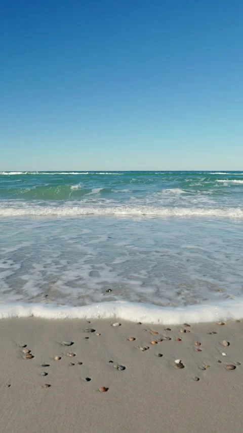 Gentle waves rolling on sandy beach on a sunny day. Stock Footage 304095268