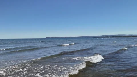 Gentle Waves Rolling onto Sandy Beach in 4K Vidéo 332943620