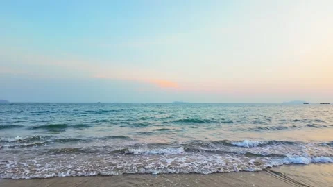 Gentle waves rolling onto a sandy beach at sunset in Sanya Stock Footage 347064697