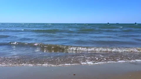 Gentle Waves Rolling Toward Shore with Distant Ships on the Horizon Stock Footage 310233092