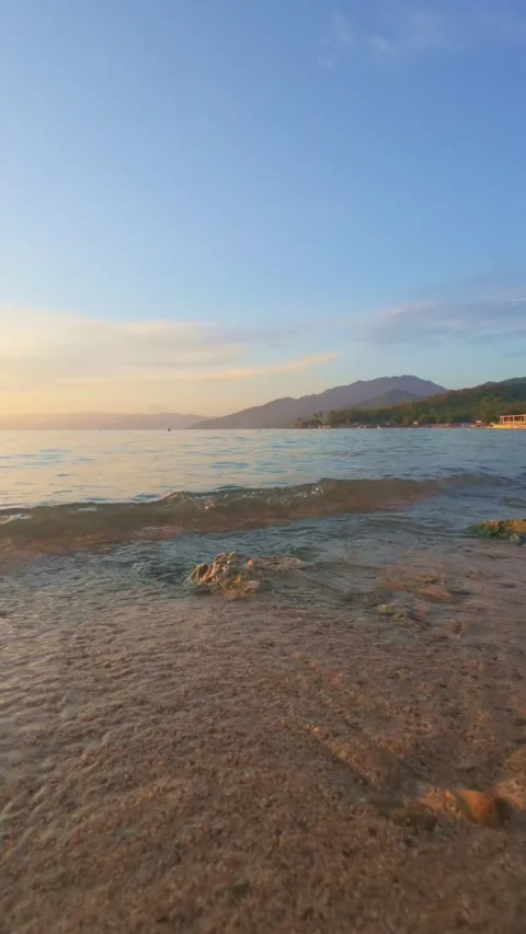 Gentle Waves on a Sandy Beach at Sunset Stock Footage 305977430