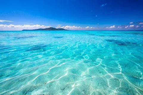 Gentle waves of the sea surface with the reflection of the blue sky. Stock Photos